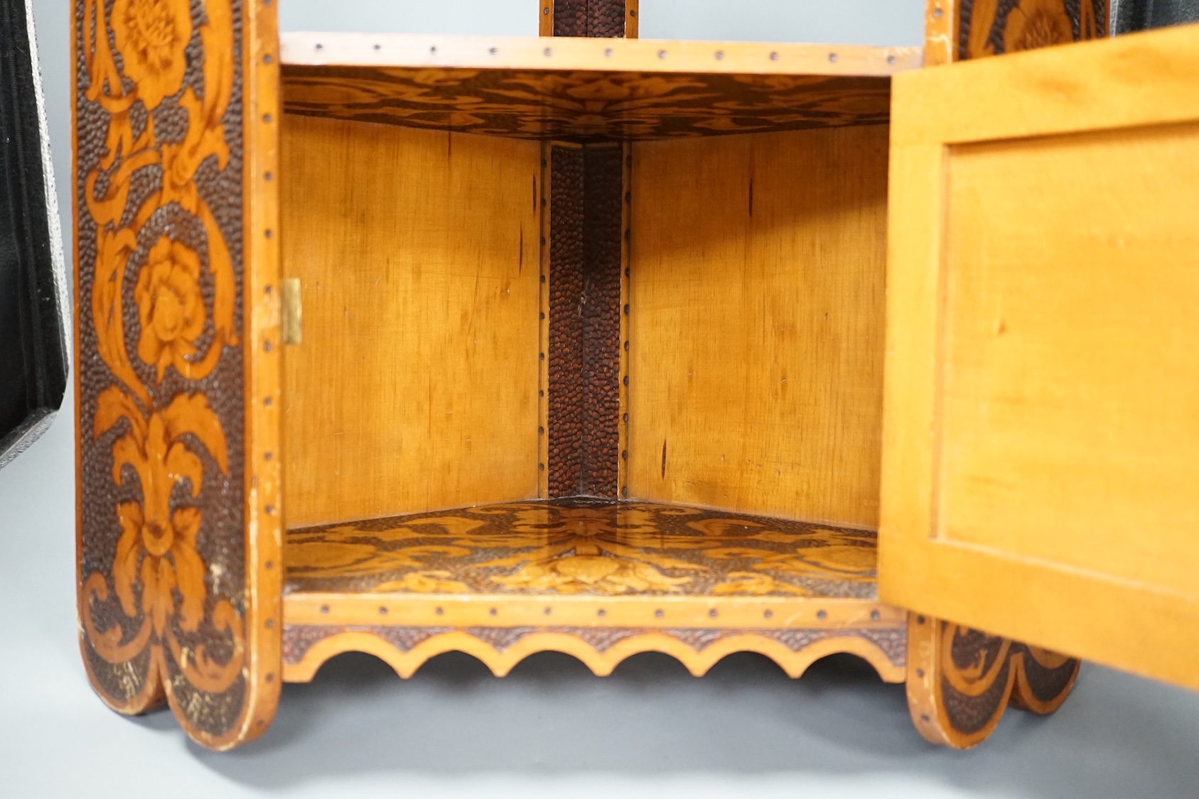 A pokerwork hanging corner cabinet, 58cm